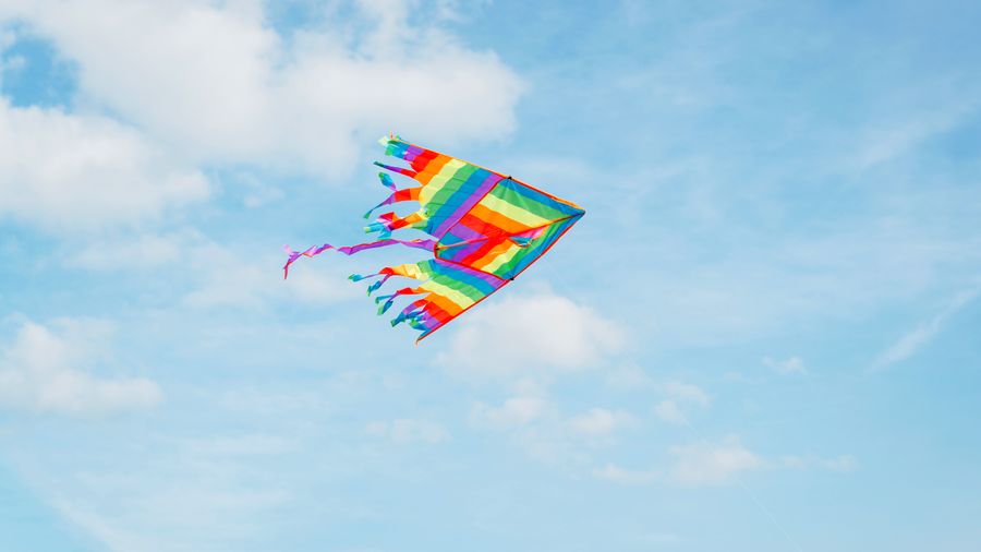 Fliegender Kite vor blauem Himmel.